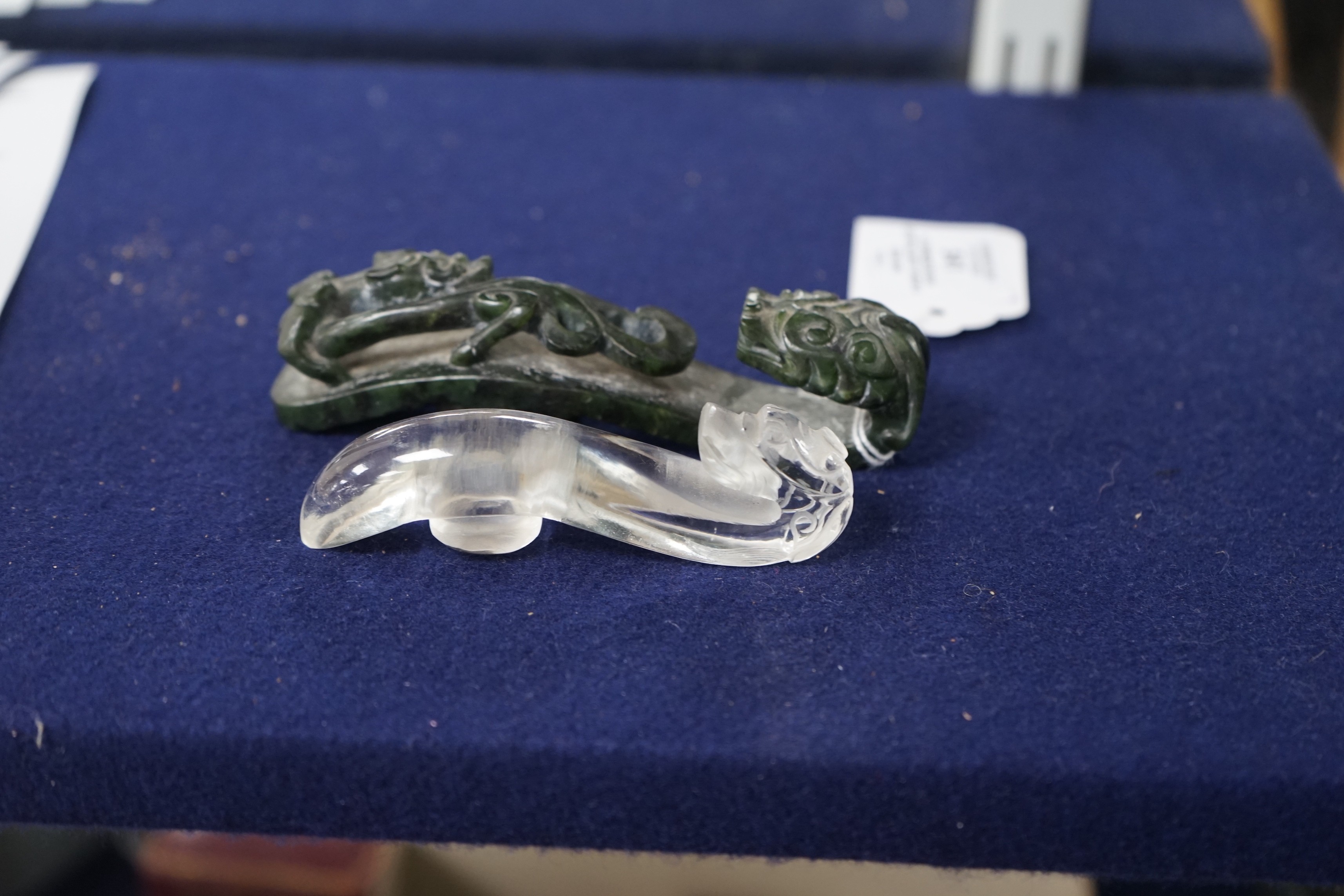 A Chinese rock crystal belt hook and a Chinese spinach green jade belt hook (2), largest 12cms long